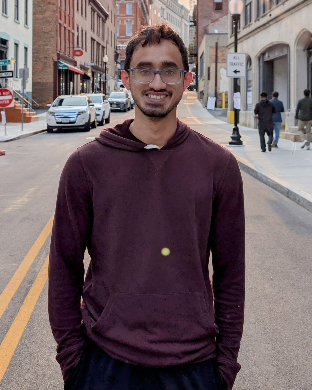 Aneesh Krishna standing on a city street at sunset